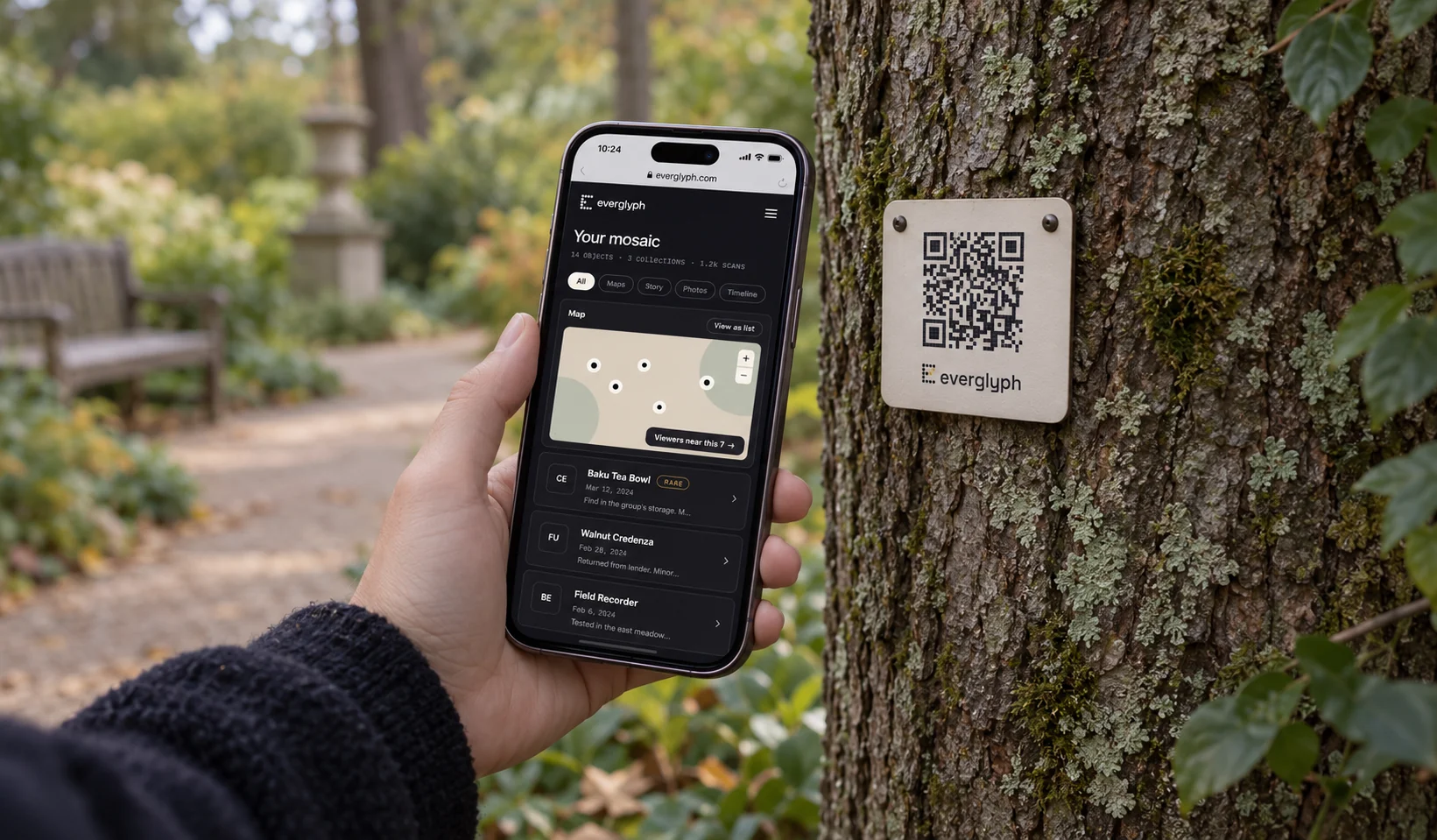 A person scanning an Everglyph garden-tree record in a quiet outdoor setting