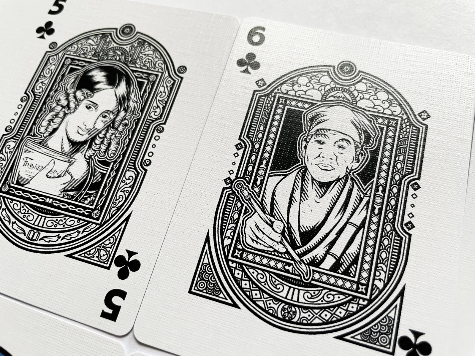 Close view of two illustrated Clubs cards.