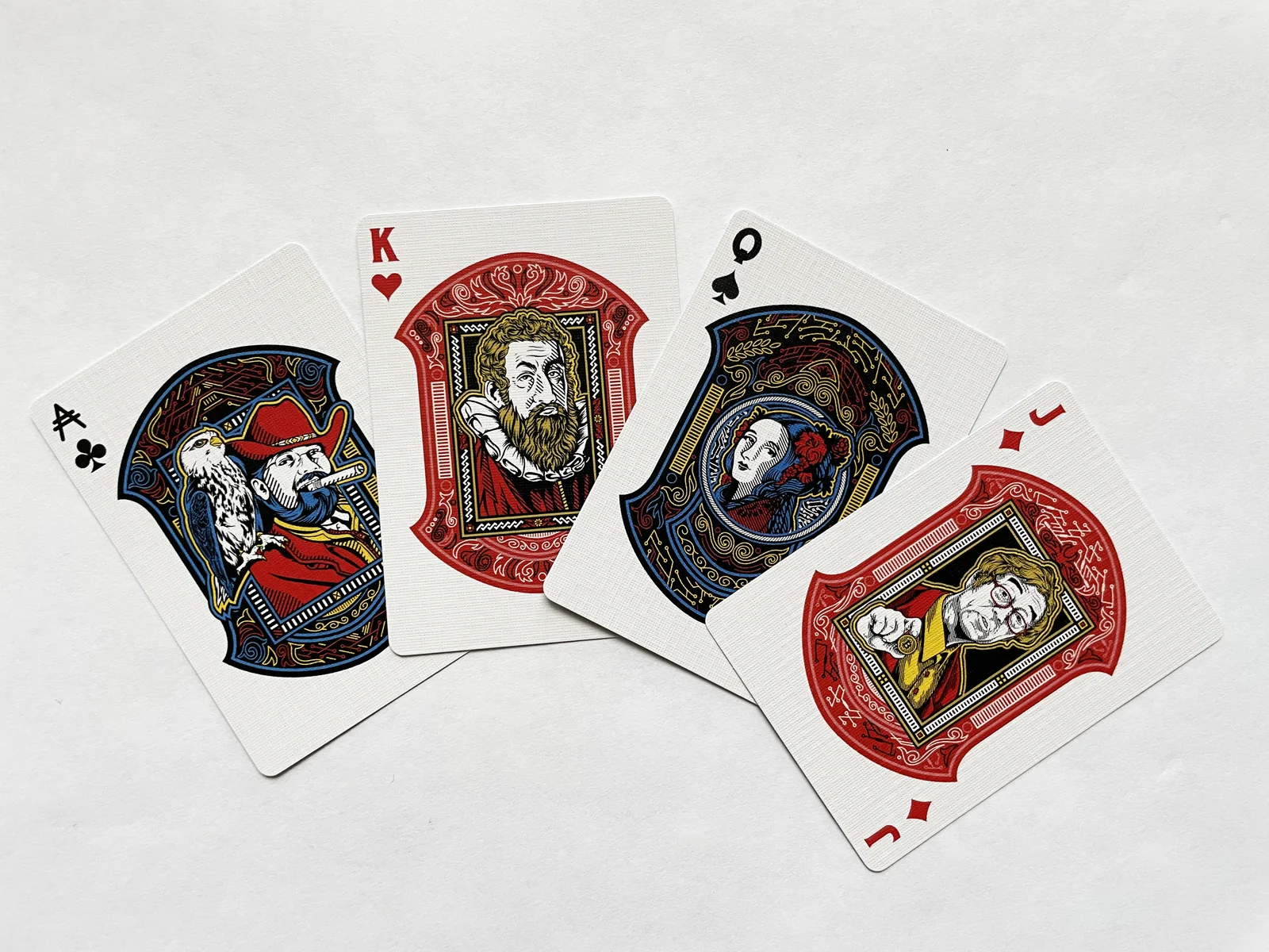 Four illustrated playing cards fanned on a pale surface.