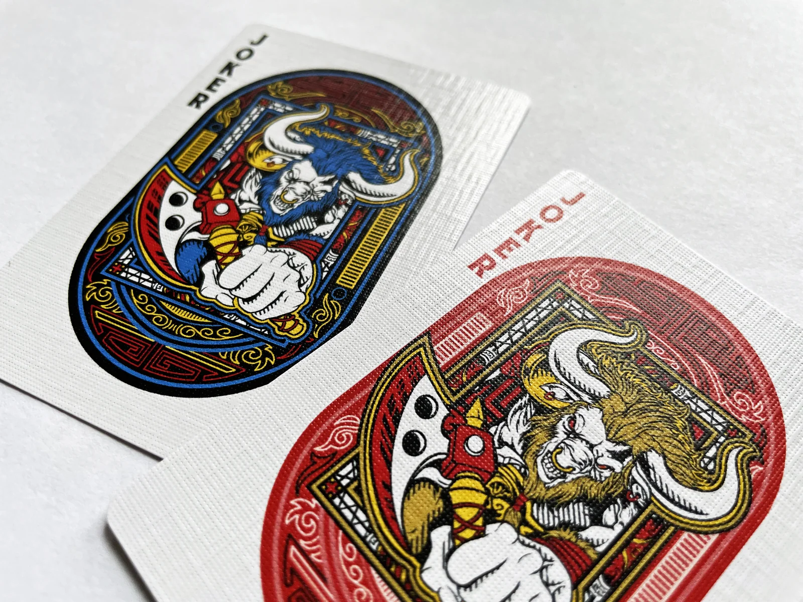 Two illustrated joker playing cards on a pale surface.